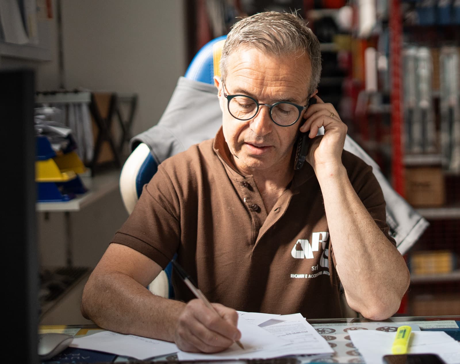 Paolo al telefono mentre prende nota della richiesta di un cliente