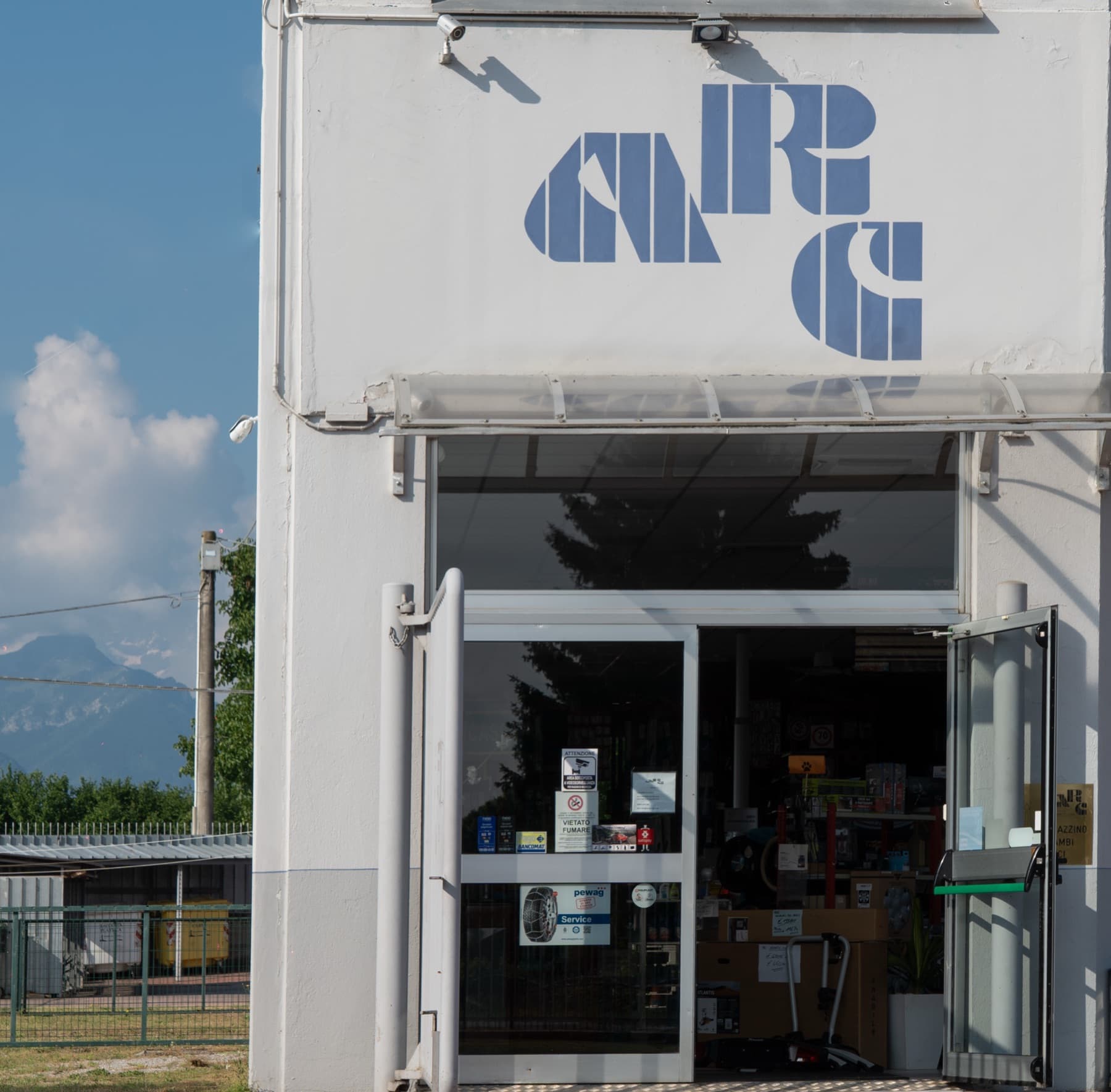 La sede ARC di Via Valle Maira a Cuneo, con il logo dipinto sulla facciata e le Alpi sullo sfondo
