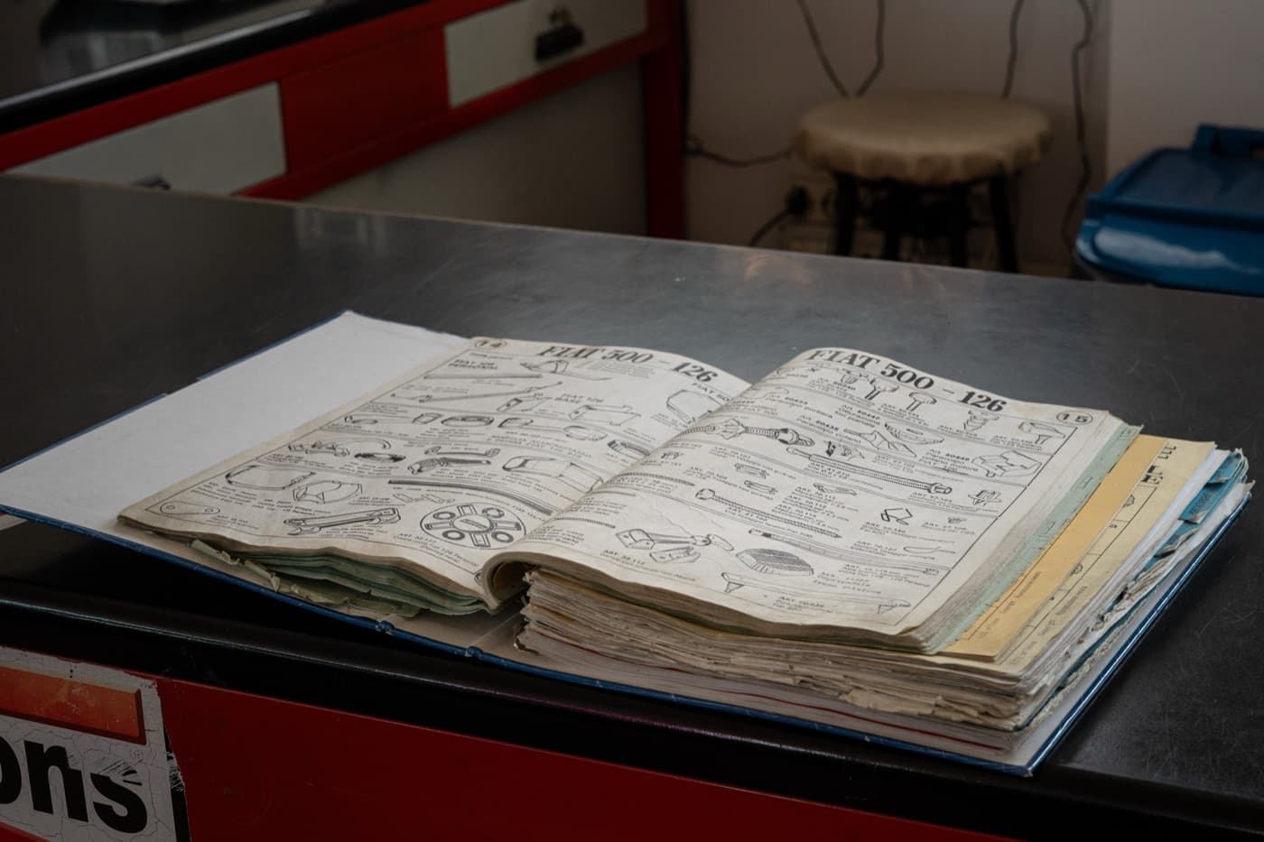 Un catalogo ricambi FIAT d'epoca aperto sul banco di ARC