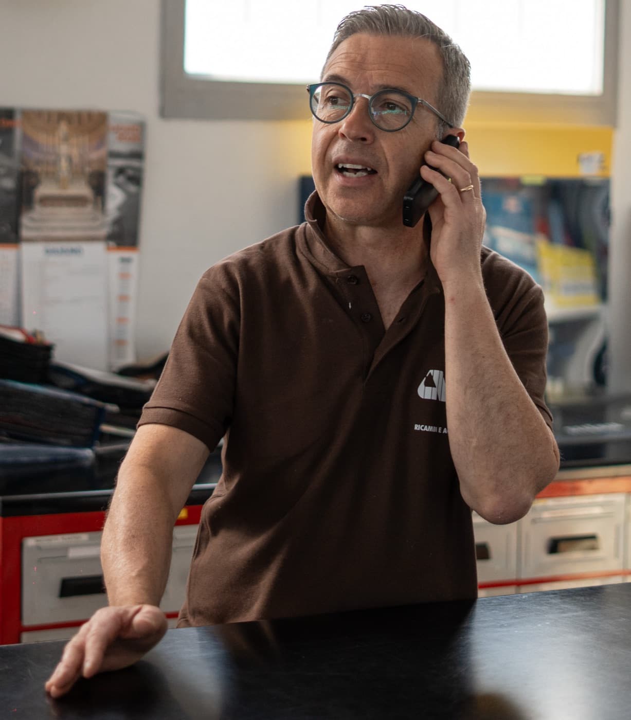 Al telefono con un cliente, al banco del negozio