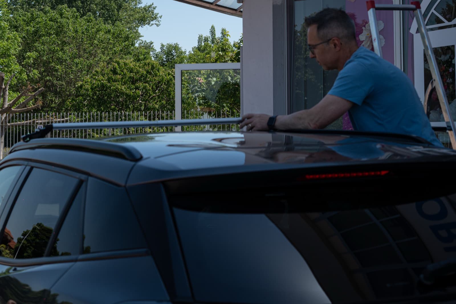 La posa delle barre portatutto sul tetto di un'auto, davanti al negozio